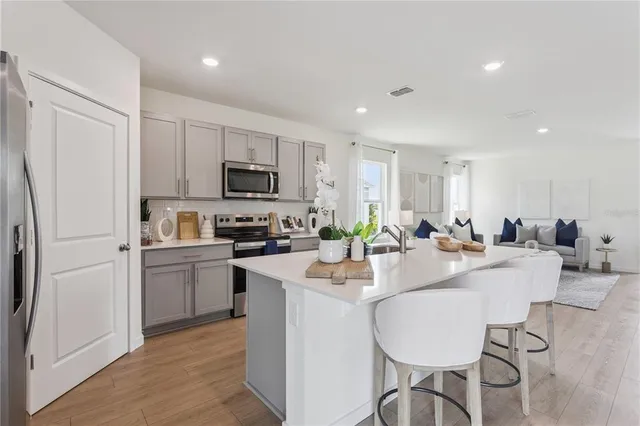 a kitchen with appliances a sink and a refrigerator