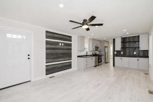 a kitchen with granite countertop a sink stainless steel appliances and cabinets