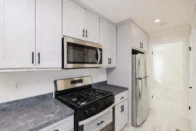 a kitchen with stainless steel appliances granite countertop a sink stove and microwave