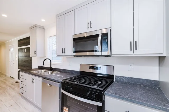 a view of empty room with wooden floor and windows