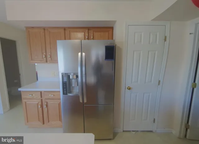 a metallic refrigerator freezer sitting in a kitchen
