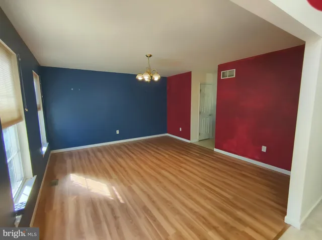 an empty room with a window and a ceiling fan