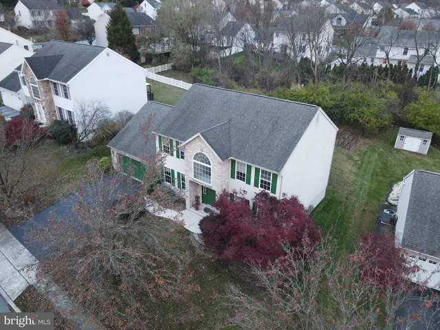a aerial view of a house with a yard and a large tree