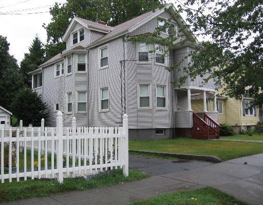 a front view of a house with a garden and plants
