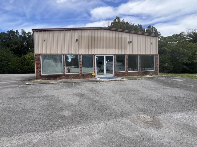 a front view of a house with basket ball court and trees