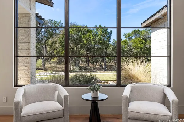 a living room with furniture a large window a flat screen tv and outdoor seating