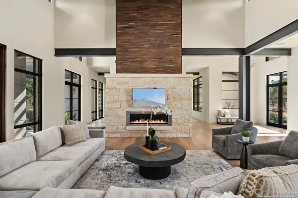 a living room with fireplace furniture and a large window