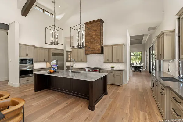 a large kitchen with stainless steel appliances granite countertop a lot of counter space and wooden floors