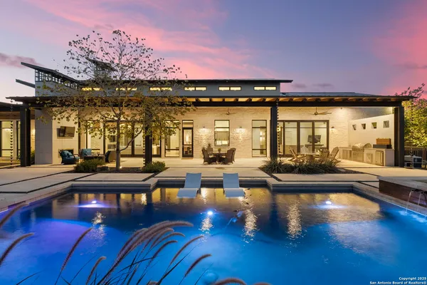 a swimming pool view with a seating space and a garden view
