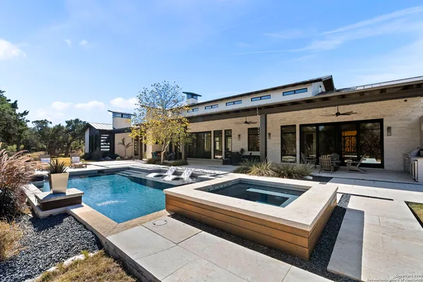 a view of a house with swimming pool and sitting area