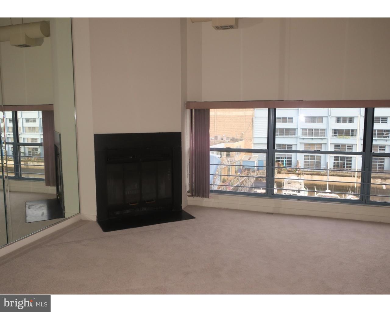 3 North Christopher Columbus Boulevard, Unit 405 Philadelphia, PA 19106 - Photo 2 of 20 a living room with a large window and a fireplace