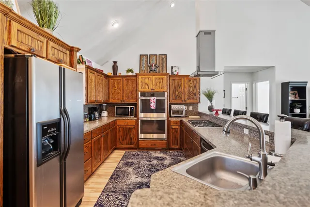 a kitchen with stainless steel appliances granite countertop a refrigerator and a sink