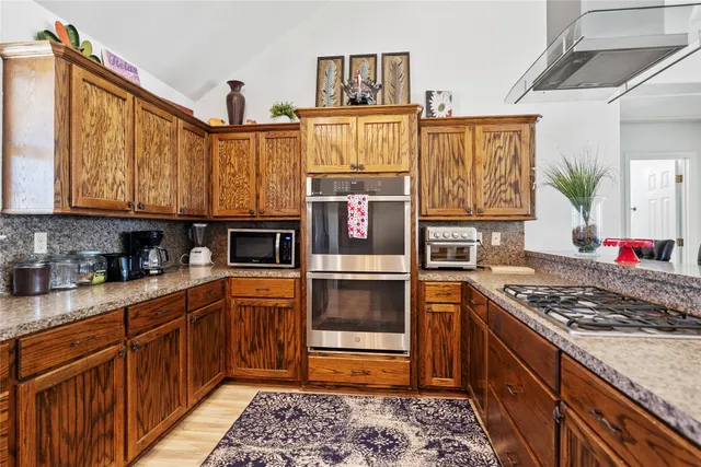 a kitchen with stainless steel appliances granite countertop a stove and a refrigerator