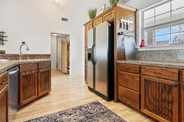 a kitchen with stainless steel appliances granite countertop a refrigerator and a sink