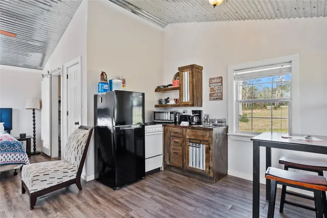 a kitchen with stainless steel appliances kitchen island wooden floors and wooden cabinets