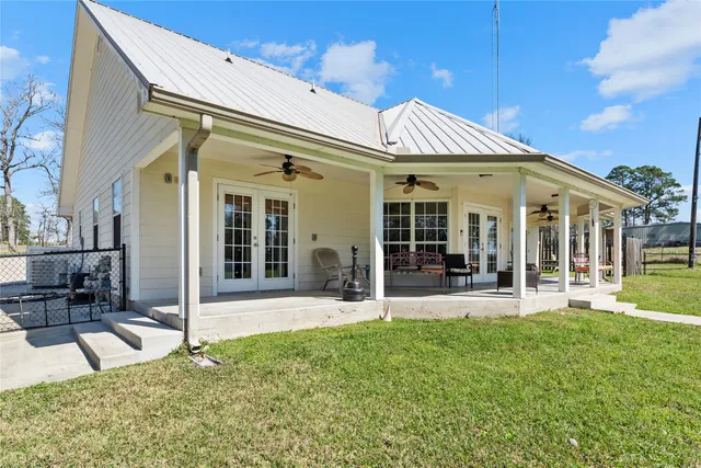 a view of a white house with a big yard and large tree