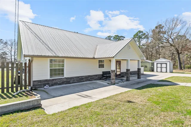 a front view of a house with swimming pool and sitting area