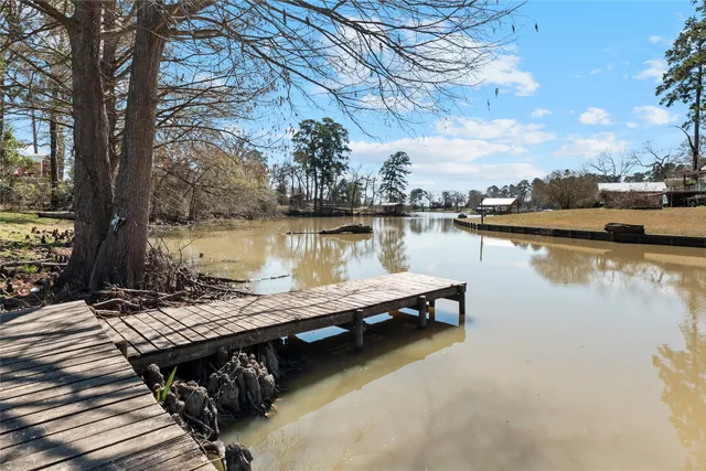 a view of a lake with wooden deck and trees