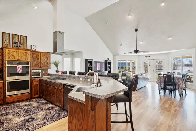 a kitchen with stainless steel appliances granite countertop a sink counter space and chairs