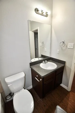 a bathroom with a granite countertop toilet sink and mirror