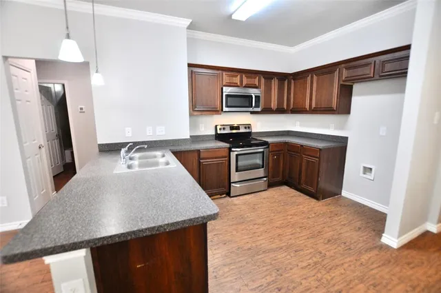 a kitchen with stainless steel appliances granite countertop a sink stove and refrigerator