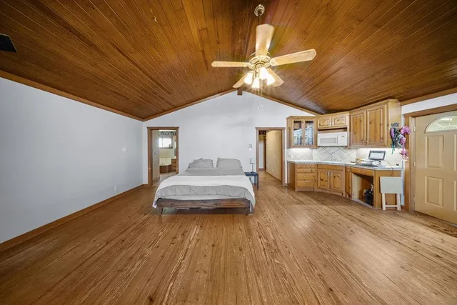 a spacious bedroom with a bed and a chandelier
