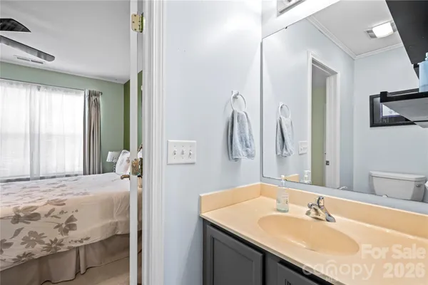 a en suite bathroom with a granite countertop sink and a mirror