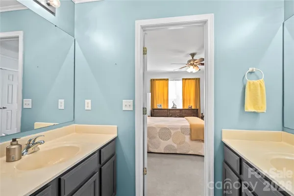 a en suite bathroom with a granite countertop sink and a mirror