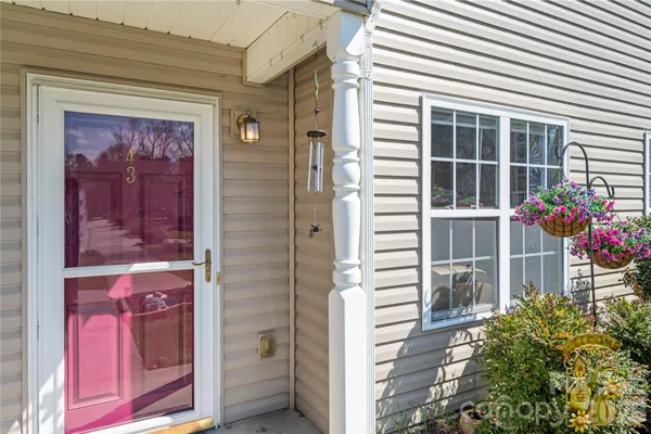 a front view of a house with a potted plant and a window
