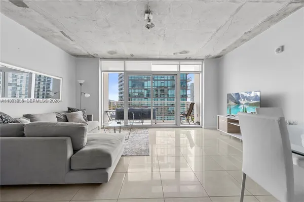 a living room with furniture and large windows