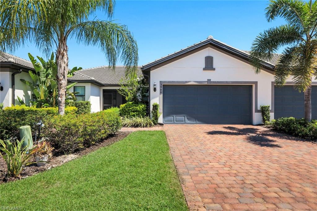 5948 Mayflower Way Ave Maria, FL 34142 - Photo 1 of 48 a front view of yellow house with a yard and palm trees