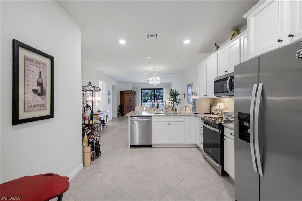 5948 Mayflower Way Ave Maria, FL 34142 - Photo 11 of 48 a kitchen with stainless steel appliances kitchen island granite countertop a refrigerator and a stove top oven