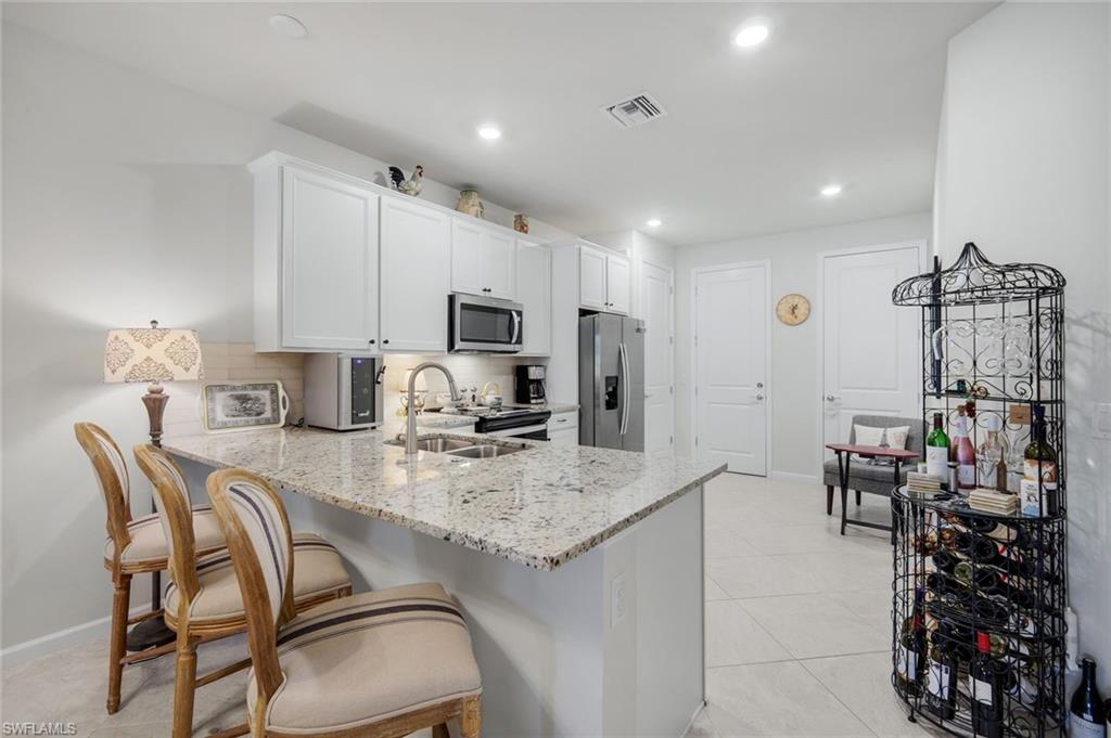 5948 Mayflower Way Ave Maria, FL 34142 - Photo 13 of 48 a kitchen with refrigerator a sink and a stove