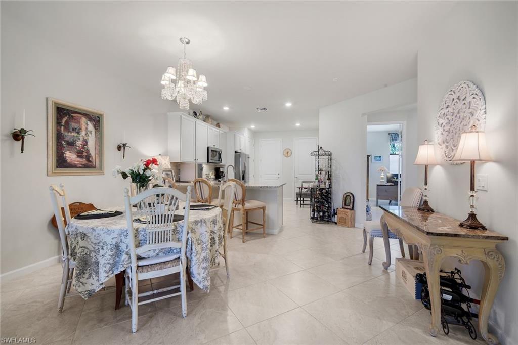 5948 Mayflower Way Ave Maria, FL 34142 - Photo 14 of 48 a view of a dining room with furniture and chandelier