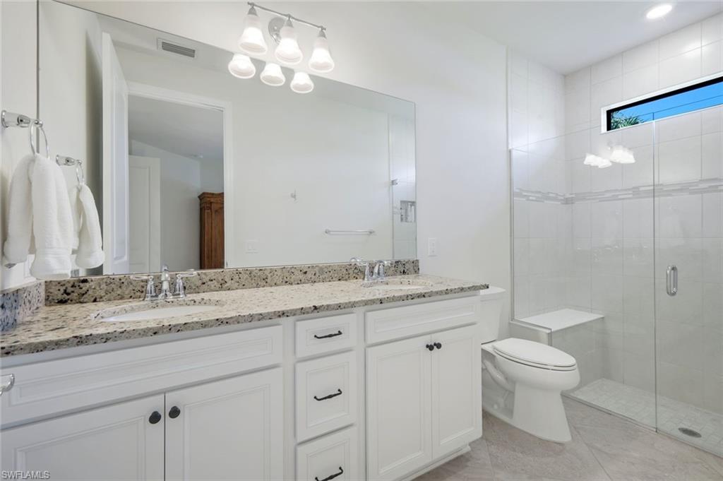 5948 Mayflower Way Ave Maria, FL 34142 - Photo 19 of 48 a bathroom with a granite countertop sink a toilet and a large mirror