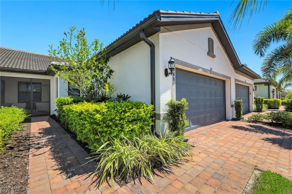 5948 Mayflower Way Ave Maria, FL 34142 - Photo 3 of 48 a front view of a house with garden