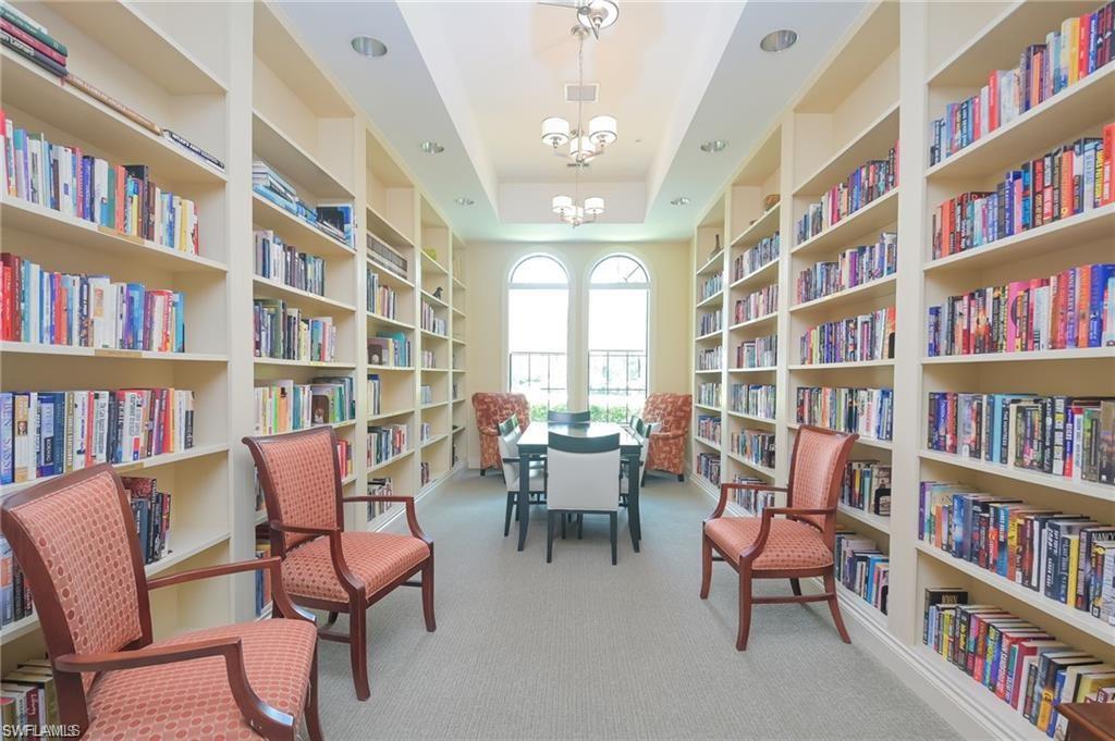 5948 Mayflower Way Ave Maria, FL 34142 - Photo 44 of 48 a living room with furniture lots of books and a large window