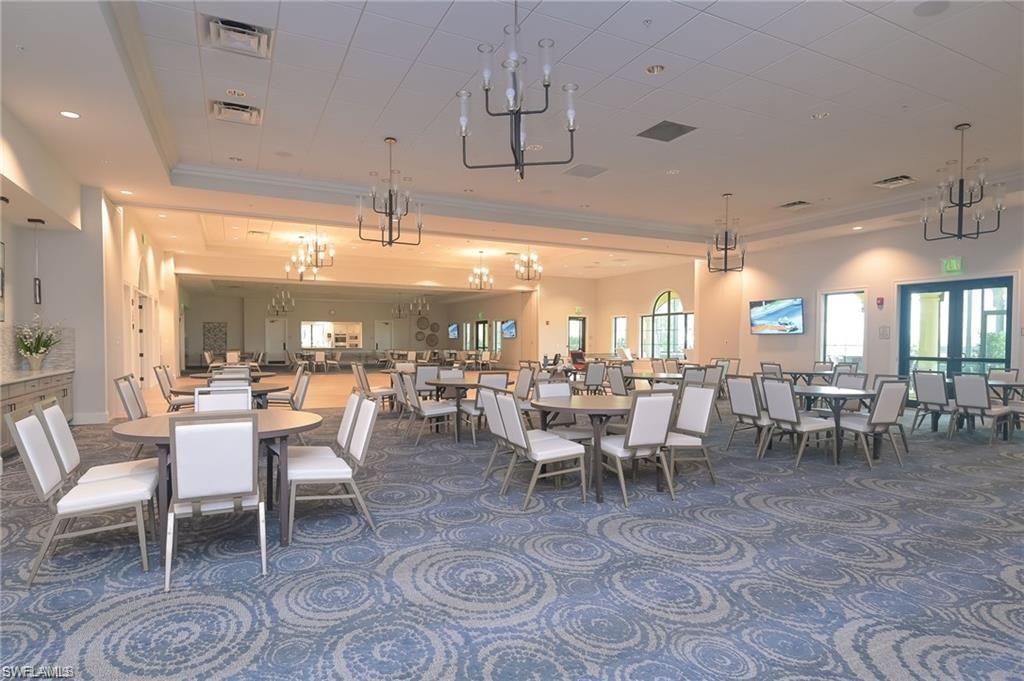 5948 Mayflower Way Ave Maria, FL 34142 - Photo 46 of 48 a room with lots of tables a large window and chairs