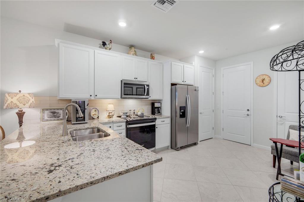 5948 Mayflower Way Ave Maria, FL 34142 - Photo 9 of 48 a kitchen with stainless steel appliances granite countertop a sink refrigerator and cabinets
