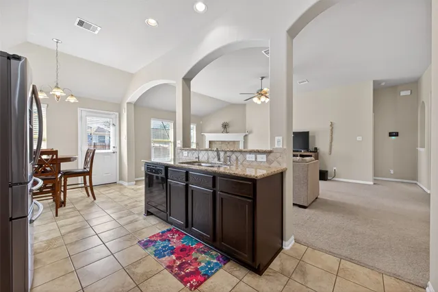 a kitchen with granite countertop a refrigerator stove and microwave