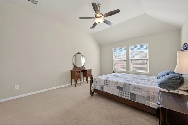 a spacious bedroom with a bed and a chandelier