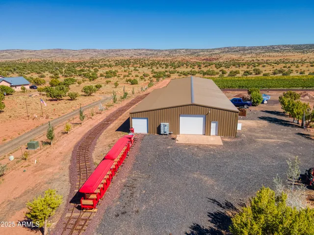 a kitchen with granite countertop a table chairs microwave and refrigerator