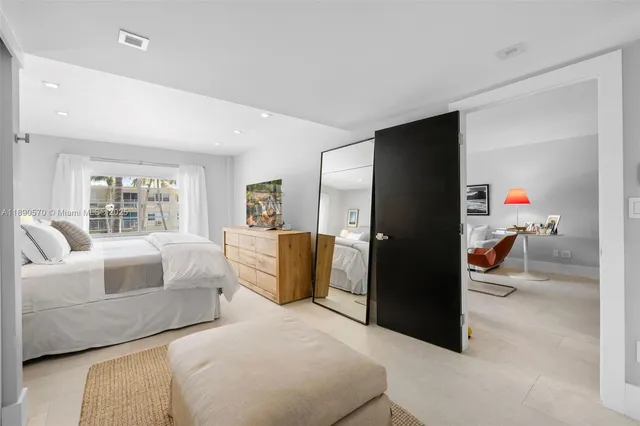 a bedroom with a bed couch and a large window