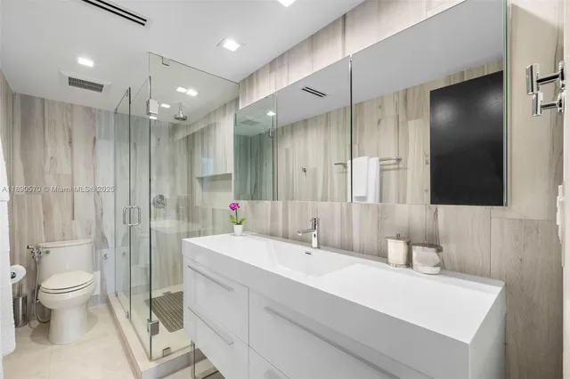 a bathroom with a sink a toilet and shower