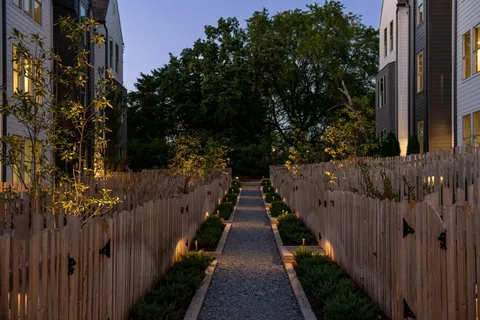 a view of a pathway of a house with wooden fence