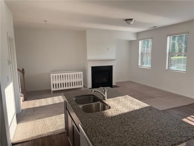 a kitchen with granite countertop a sink and a stove top oven
