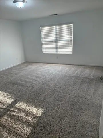 an empty room with a empty space & windows