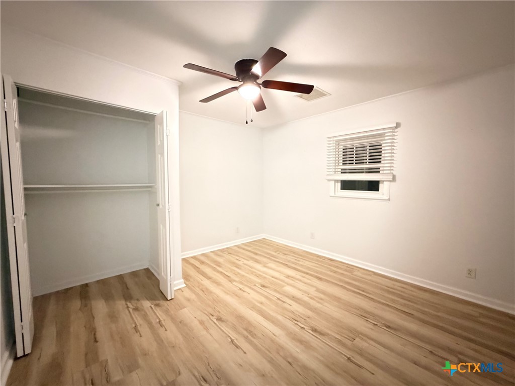 425 Woodland Point Road Belton, TX 76513 - Photo 24 of 27 a view of an empty room with wooden floor and a ceiling fan