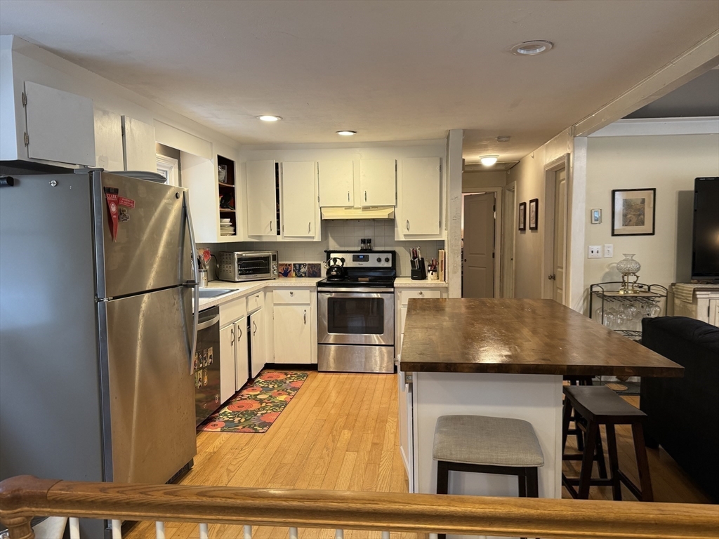 77 Branch Road East Bridgewater, MA 02333 - Photo 8 of 16 a kitchen with cabinets a refrigerator and a stove top oven with wooden floor