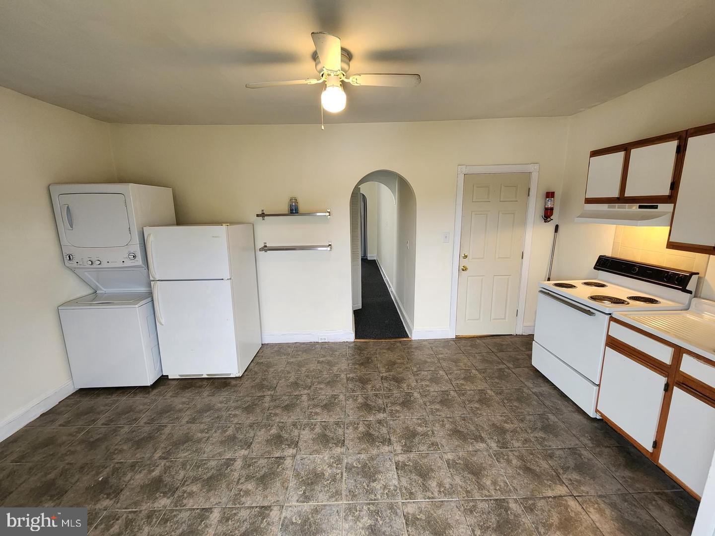 218 Osborn Street, Unit 2 Philadelphia, PA 19128 - Photo 3 of 6 a kitchen with kitchen island a stove a sink and a refrigerator